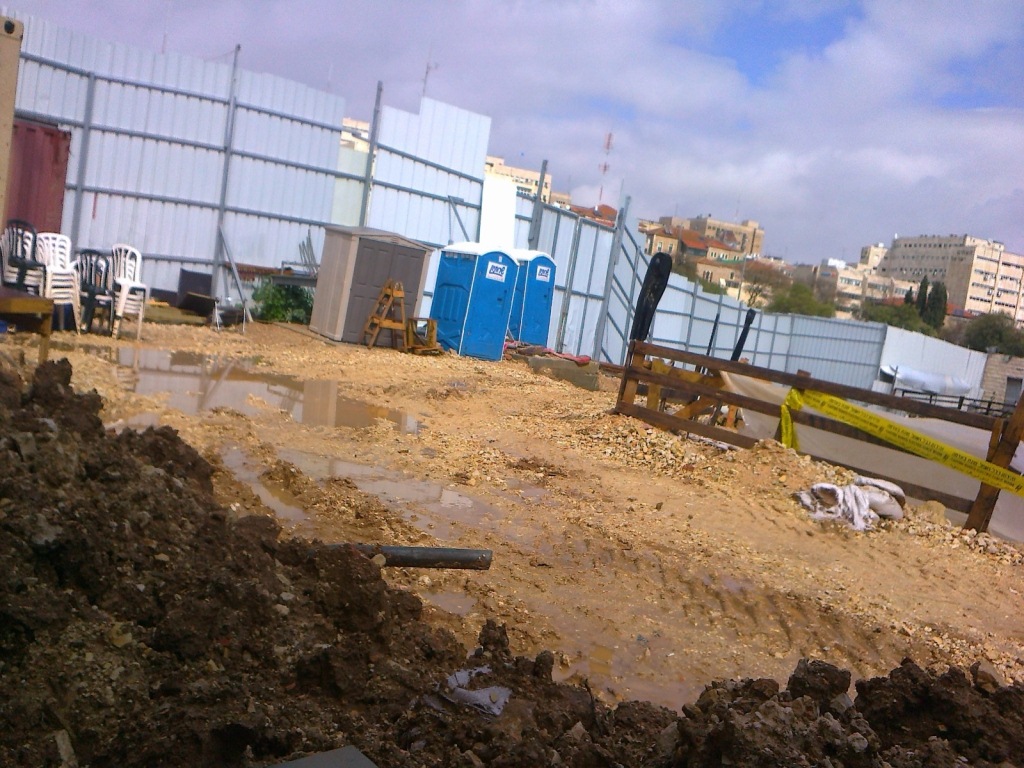 IAA excavation pit inside SWC construction showing inner enclosure wall and portable toilets rented for use by IAA teams onsite