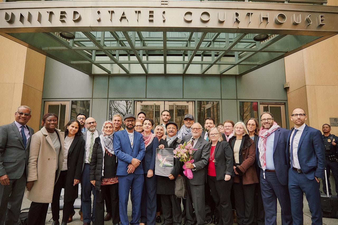 Center for Constitutional Rights attorneys, staff, and clients stand in front of a United States Courthouse building