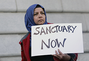 Woman holds up sign in support of  sanctuary cities