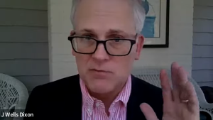 Image taken from the Youtube video. It is a picture of Senior Staff Attorney J. Wells Dixon he is wearing glasses and sits on a porch in front of a house. He is lifting one hand as he speaks.