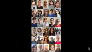 Image taken from the hashtag We Stand With Fatima video, showing 30 faces looking at the camera. In the video, they are all speaking together. The faces are a wide range of people across race, age, gender, and various other differences. There is a black background around the faces which are in the center of the image.
