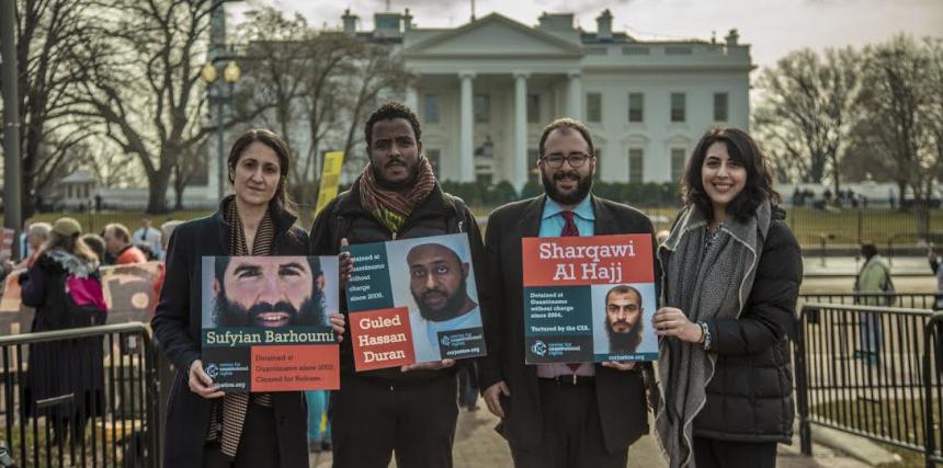 CCR Guantanamo team stands with photos of their clients in front of the White House