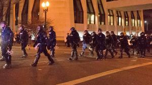 officers in riot gear marching