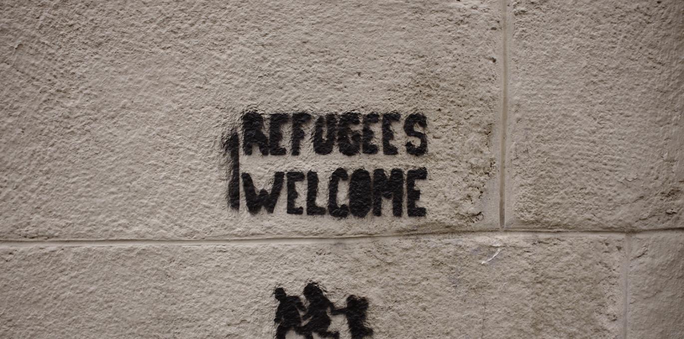 'Refugees Welcome' graffiti on cinder block wall