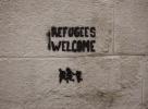 'Refugees Welcome' graffiti on cinder block wall