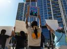 Protesters marching with one holding up sign, "Stop separating families"